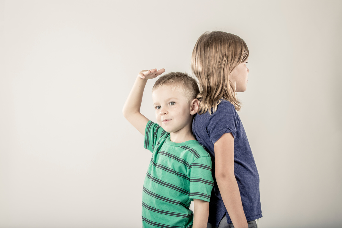 Cute Siblings Comparing Height